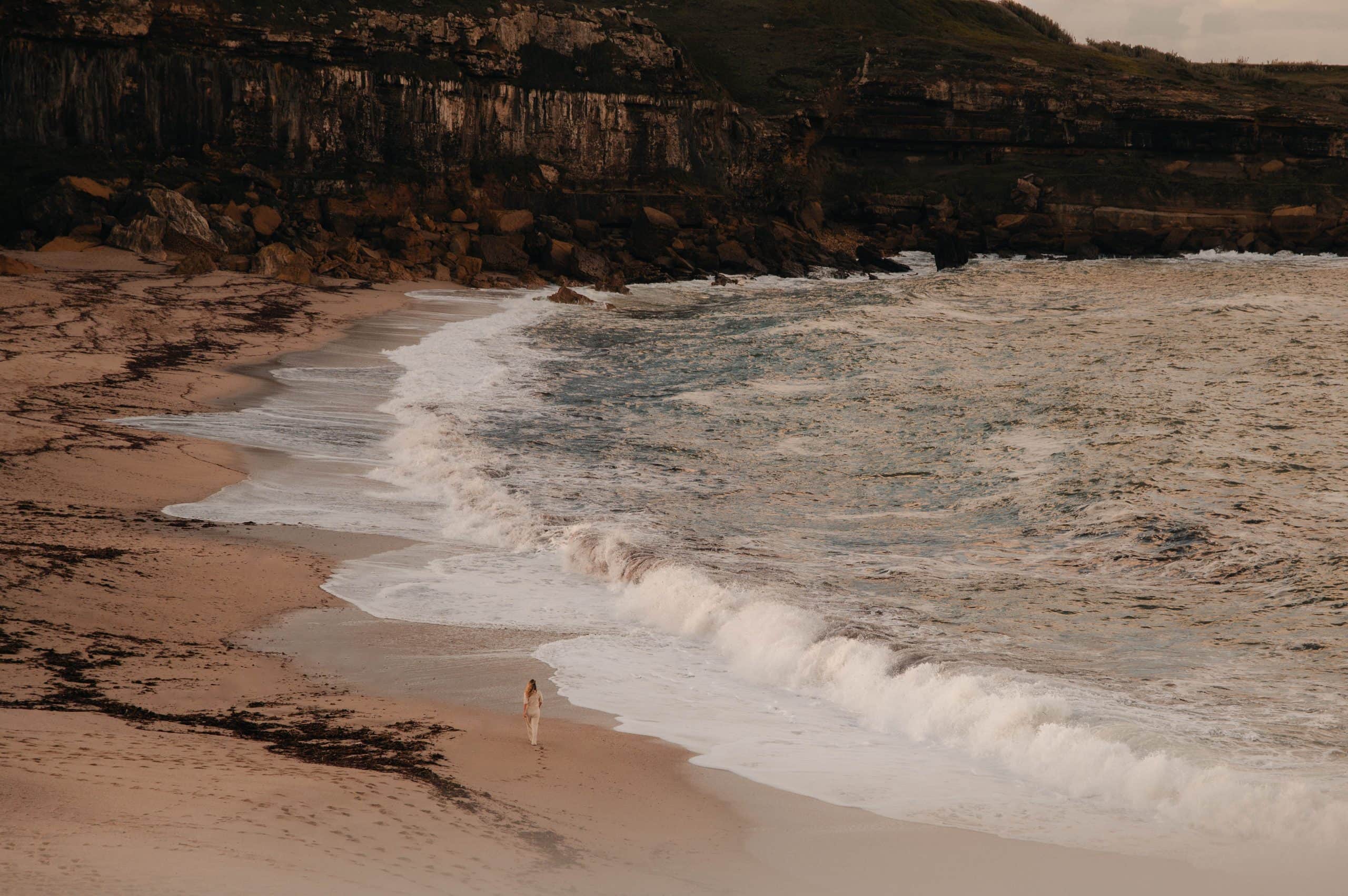 Rotskust met woelige zee en een breed strand